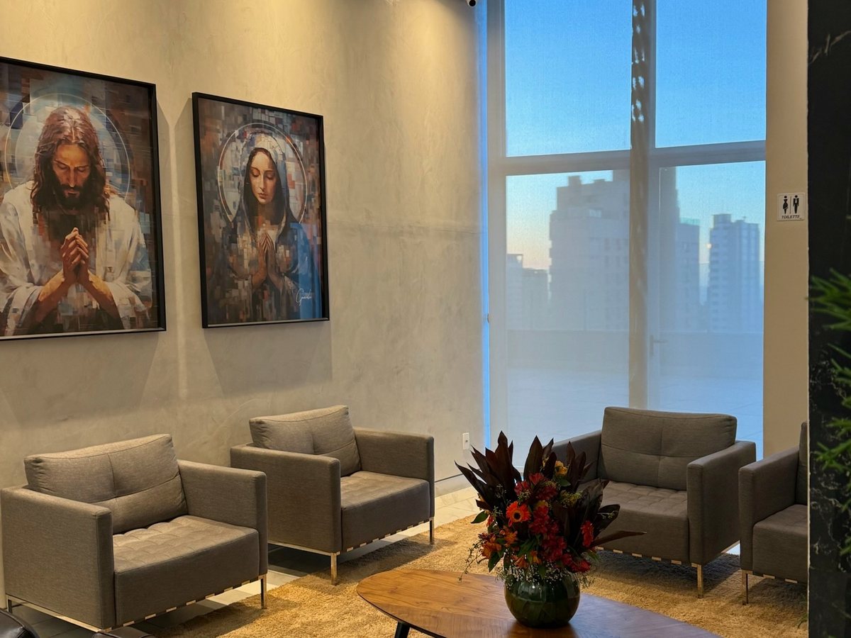 Sala de espera da AngioGold com poltronas, arranjo de flores e quadros na parede